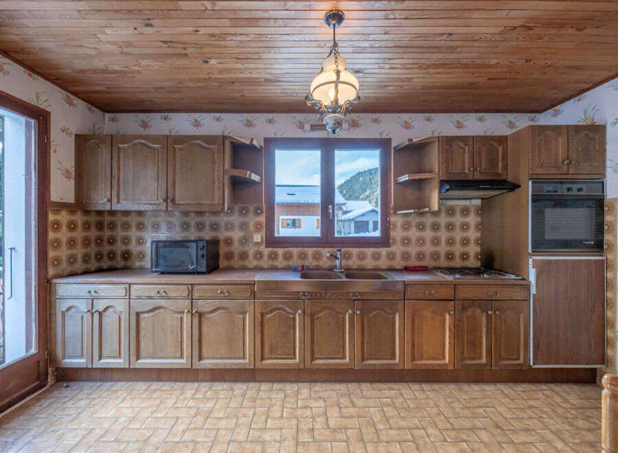Step into this charming kitchen, featuring classic wooden cabinetry and a cozy atmosphere.