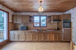 Step into this charming kitchen, featuring classic wooden cabinetry and a cozy atmosphere.