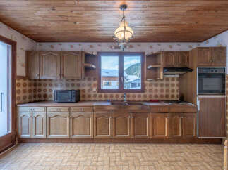 Step into this charming kitchen, featuring classic wooden cabinetry and a cozy atmosphere.