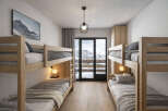This cozy bedroom features two sets of bunk beds, perfect for accommodating multiple guests or family members.