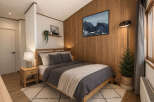 This cozy bedroom features a warm wooden accent wall and a comfortable bed, perfect for relaxation.