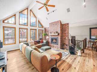 Step into luxury with this stunning property featuring a spacious living area, highlighted by a cozy fireplace and expansive windows that flood the space with natural light.