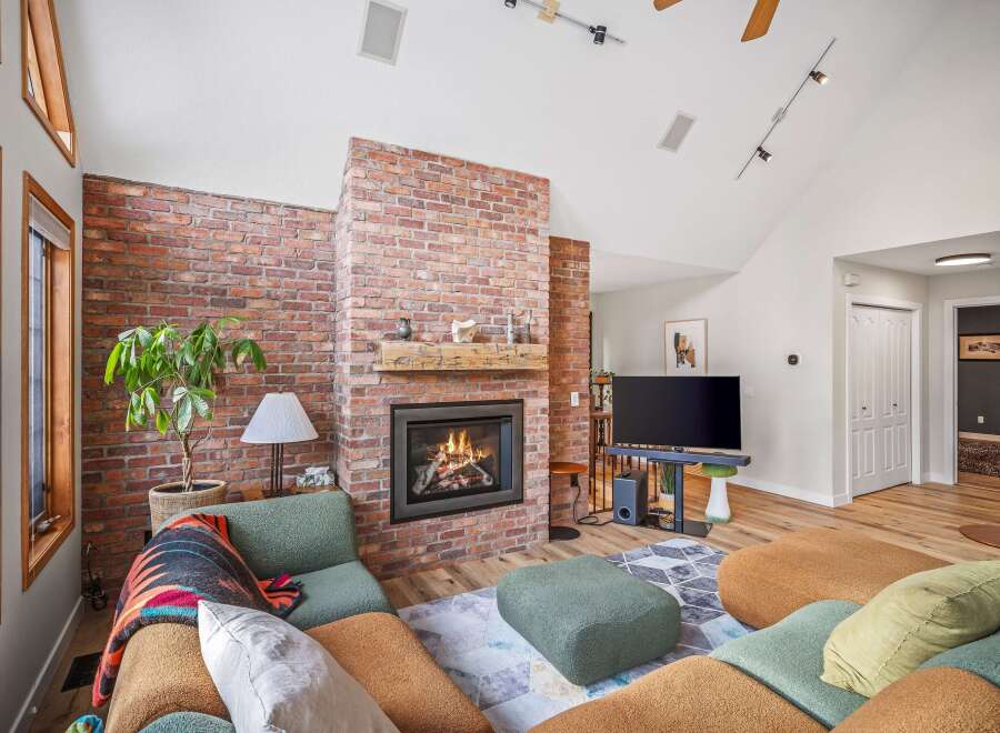 This stunning living room features a cozy brick fireplace, perfect for those chilly evenings.
