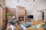 This stunning living room features a cozy brick fireplace, perfect for those chilly evenings.