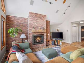 This stunning living room features a cozy brick fireplace, perfect for those chilly evenings.