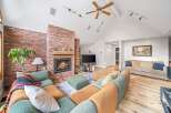 This stunning living room boasts a cozy fireplace with a brick surround, creating a warm and inviting atmosphere.