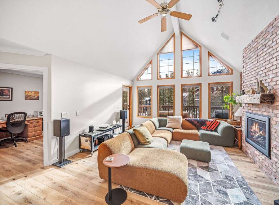 This stunning living room boasts a modern design with a cozy sectional sofa and a striking brick fireplace, perfect for relaxing evenings.