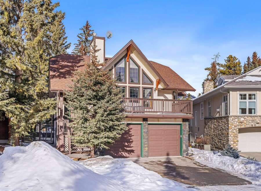 This stunning property boasts a charming mountain-style exterior with a spacious balcony and a two-car garage.