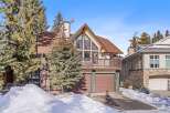 This stunning property boasts a charming mountain-style exterior with a spacious balcony and a two-car garage.
