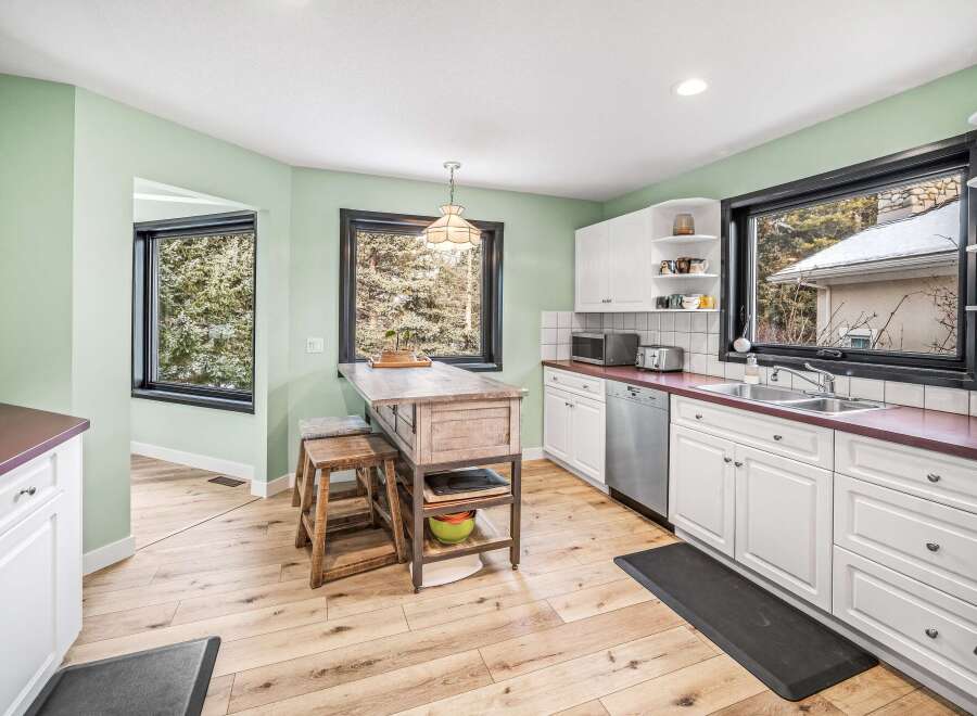 This charming kitchen boasts a bright and airy atmosphere with its light green walls and natural wood flooring.