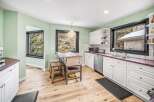 This charming kitchen boasts a bright and airy atmosphere with its light green walls and natural wood flooring.