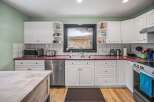 This stunning kitchen boasts a modern design with sleek white cabinetry and a vibrant red countertop, creating a stylish and inviting atmosphere.