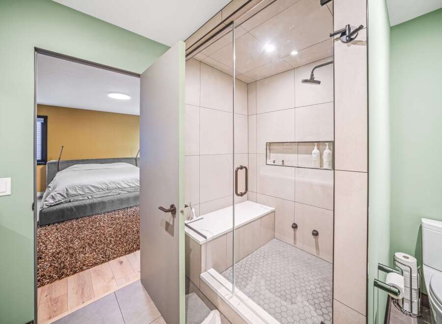 Step into luxury with this stunning bathroom featuring a modern glass-enclosed shower and elegant tile work.