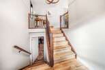 This stunning property features a beautifully designed staircase with wooden steps and a matching handrail, creating a warm and inviting atmosphere.
