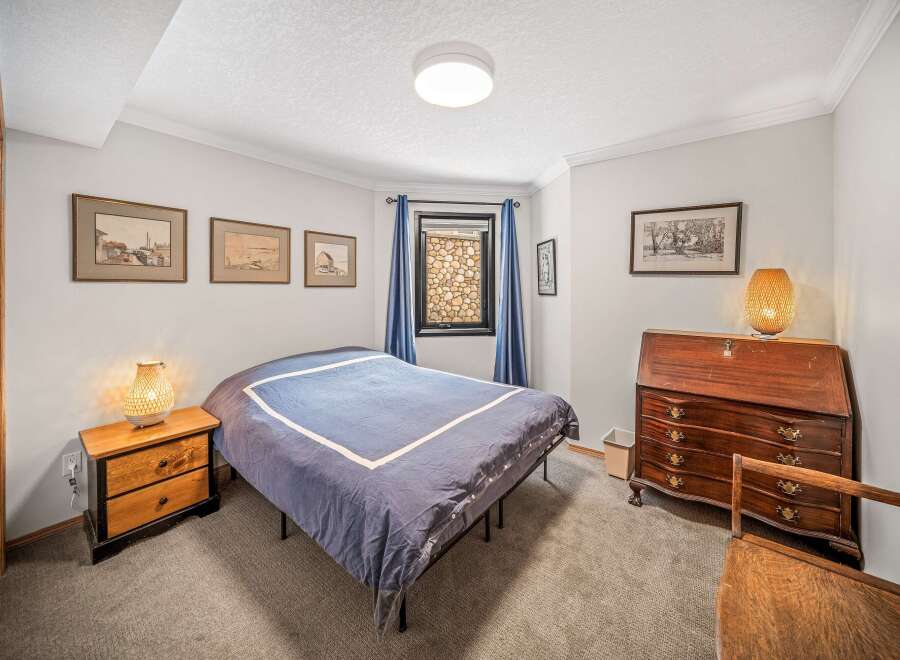 Step into this inviting bedroom, featuring a cozy bed and a charming nightstand with a stylish lamp.