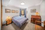 Step into this inviting bedroom, featuring a cozy bed and a charming nightstand with a stylish lamp.