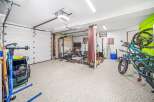 This spacious garage has been transformed into a functional home gym and storage space.