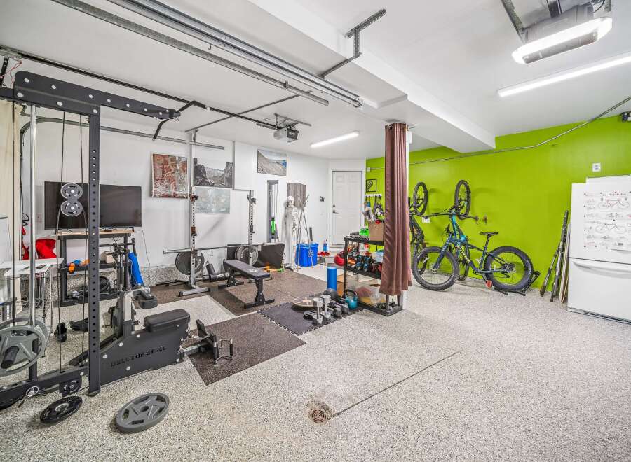This spacious garage has been transformed into a functional home gym, perfect for fitness enthusiasts.