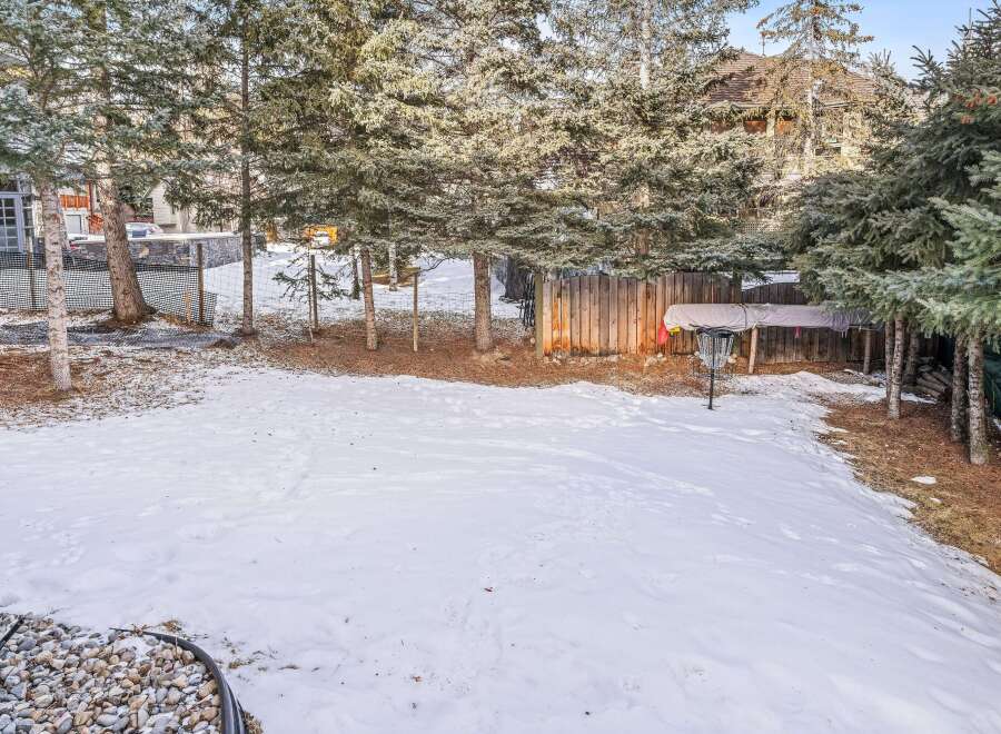 Enjoy the serene beauty of this property, featuring a spacious backyard blanketed in fresh snow.