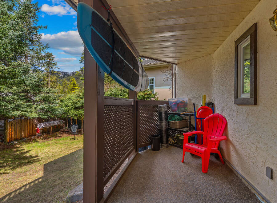 Enjoy the outdoors from this charming patio, complete with a comfortable red chair and a scenic view.