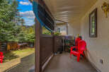 Enjoy the outdoors from this charming patio, complete with a comfortable red chair and a scenic view.