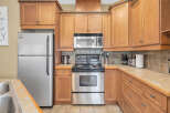 This stunning kitchen boasts beautiful wooden cabinetry and modern stainless steel appliances, creating a warm and inviting atmosphere.