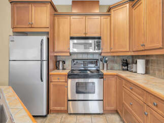 This stunning kitchen boasts beautiful wooden cabinetry and modern stainless steel appliances, creating a warm and inviting atmosphere.