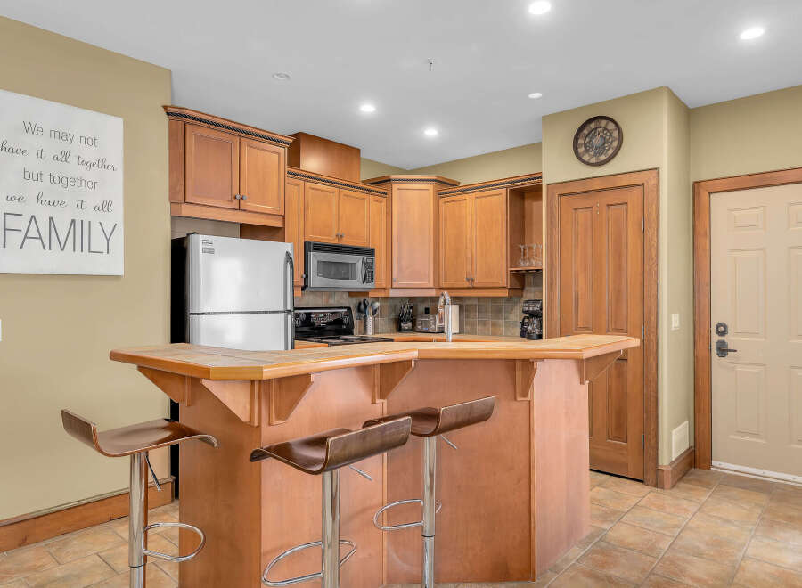 This stunning kitchen boasts beautiful wooden cabinetry and a stylish breakfast bar, perfect for casual dining and entertaining.