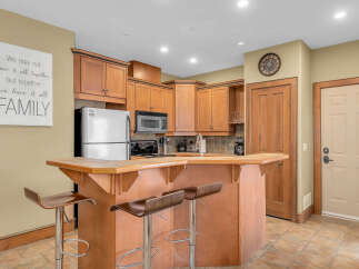 This stunning kitchen boasts beautiful wooden cabinetry and a stylish breakfast bar, perfect for casual dining and entertaining.