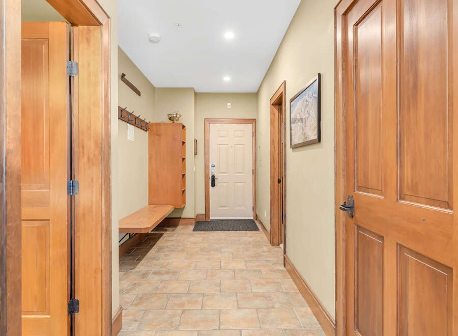 Step into this inviting entryway, showcasing beautiful wood doors and a warm, neutral color palette.
