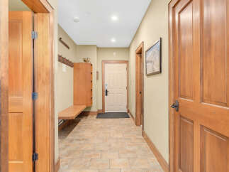 Step into this inviting entryway, showcasing beautiful wood doors and a warm, neutral color palette.