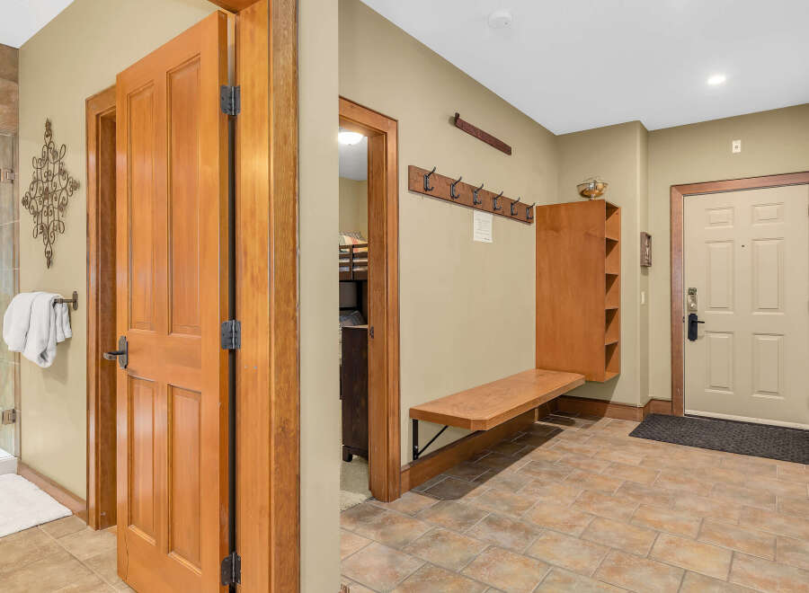 Step into this inviting entryway, showcasing beautiful wooden doors and a warm, neutral color palette.