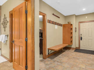 Step into this inviting entryway, showcasing beautiful wooden doors and a warm, neutral color palette.