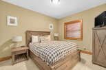This cozy bedroom features a comfortable bed with a stylish checkered comforter and a decorative pillow, perfect for a relaxing retreat.