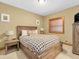 This cozy bedroom features a comfortable bed with a stylish checkered comforter and a decorative pillow, perfect for a relaxing retreat.