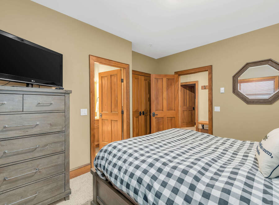 This cozy bedroom features a comfortable bed with a stylish checkered pattern, perfect for a relaxing retreat.