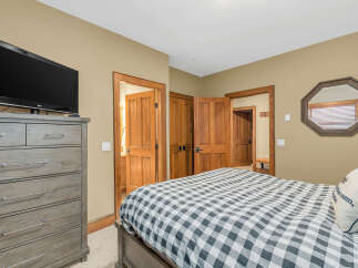This cozy bedroom features a comfortable bed with a stylish checkered pattern, perfect for a relaxing retreat.