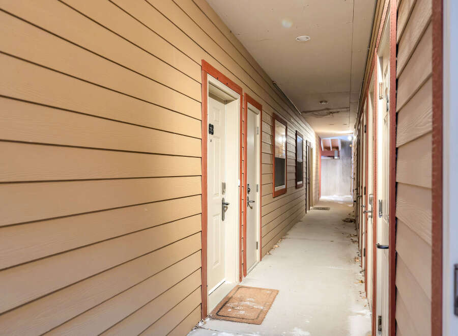 Explore this inviting apartment complex hallway, featuring a warm and welcoming atmosphere.