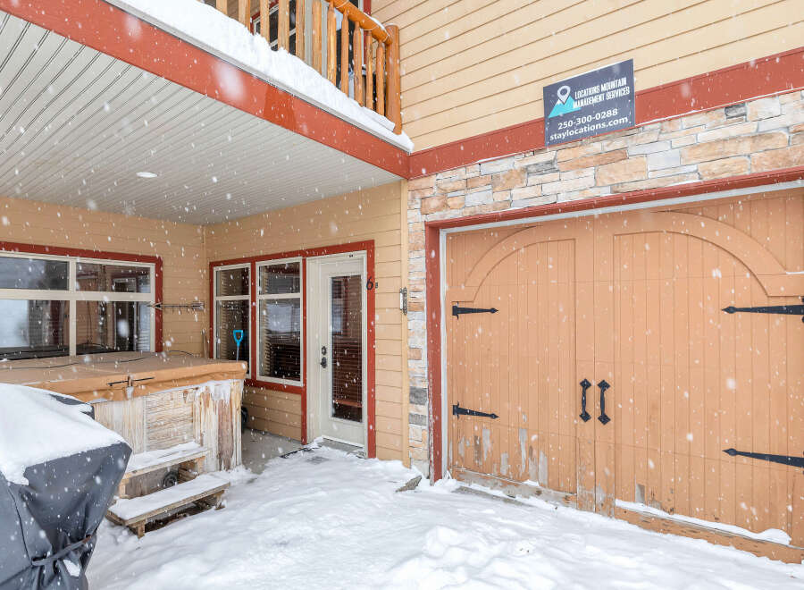 This charming property features a cozy entrance with a covered porch, perfect for enjoying snowy days.