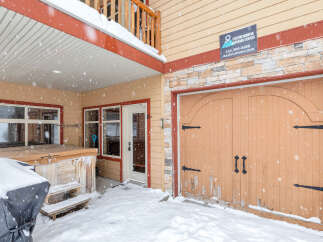This charming property features a cozy entrance with a covered porch, perfect for enjoying snowy days.