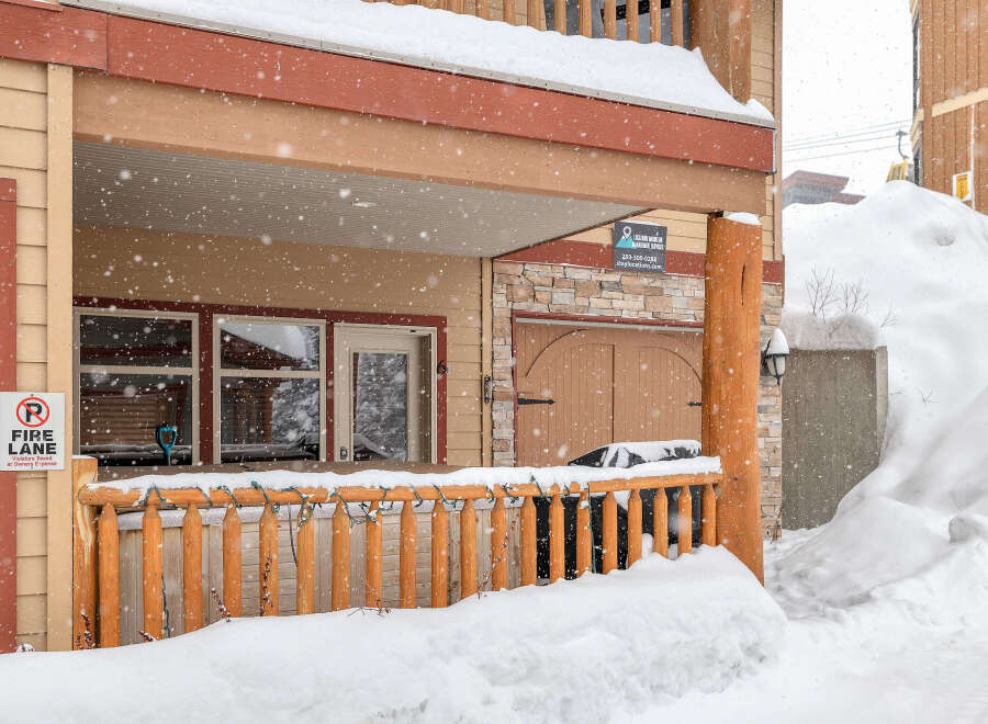 This charming property features a cozy porch, perfect for enjoying snowy mountain views.