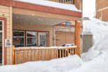 This charming property features a cozy porch, perfect for enjoying snowy mountain views.