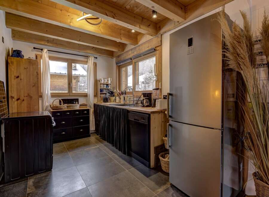 Step into this charming kitchen, boasting a rustic design with exposed wooden beams and a modern touch.