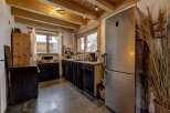 Step into this charming kitchen, boasting a rustic design with exposed wooden beams and a modern touch.
