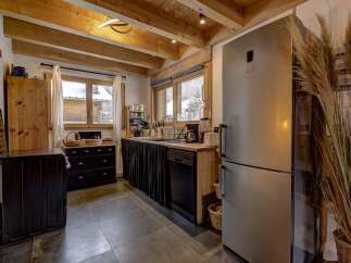 Step into this charming kitchen, boasting a rustic design with exposed wooden beams and a modern touch.