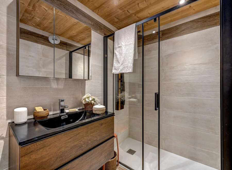 Step into a beautifully designed bathroom featuring a sleek black sink and a modern glass shower enclosure.
