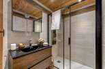 Step into a beautifully designed bathroom featuring a sleek black sink and a modern glass shower enclosure.