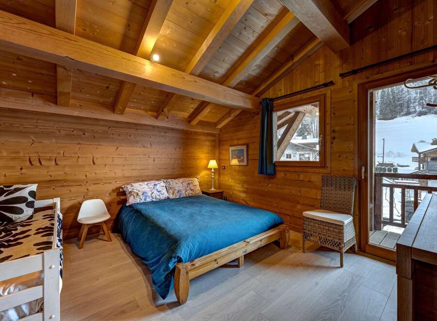 Experience the charm of this cozy wooden chalet bedroom, perfect for a mountain getaway.