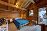 Experience the charm of this cozy wooden chalet bedroom, perfect for a mountain getaway.