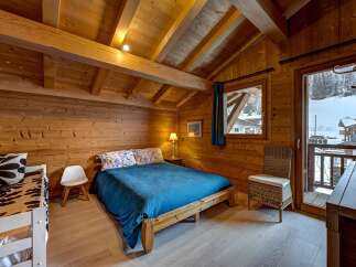 Experience the charm of this cozy wooden chalet bedroom, perfect for a mountain getaway.